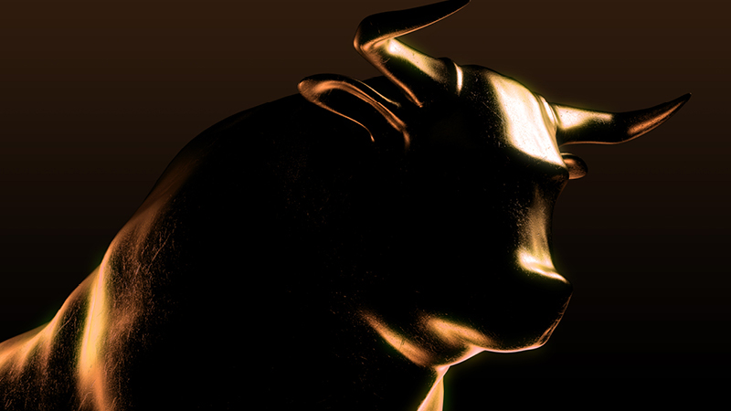 An allusion to the bull market on the commodity exchange: a bull statue made of copper shines against a black background. Only the horns and the silhouette are illuminated.