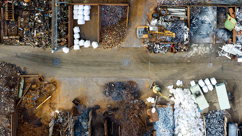 A recycling factory photographed from above where recyclables are neatly separated. Exemplary for the sustainability topic “Lifecycle Management”