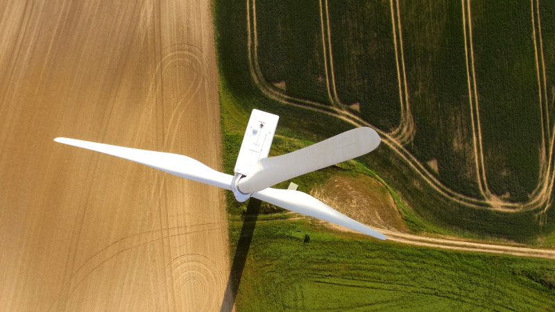 A wind turbine photographed from above, illustrating that positive change can be brought about with investments, the example here being renewable energies.